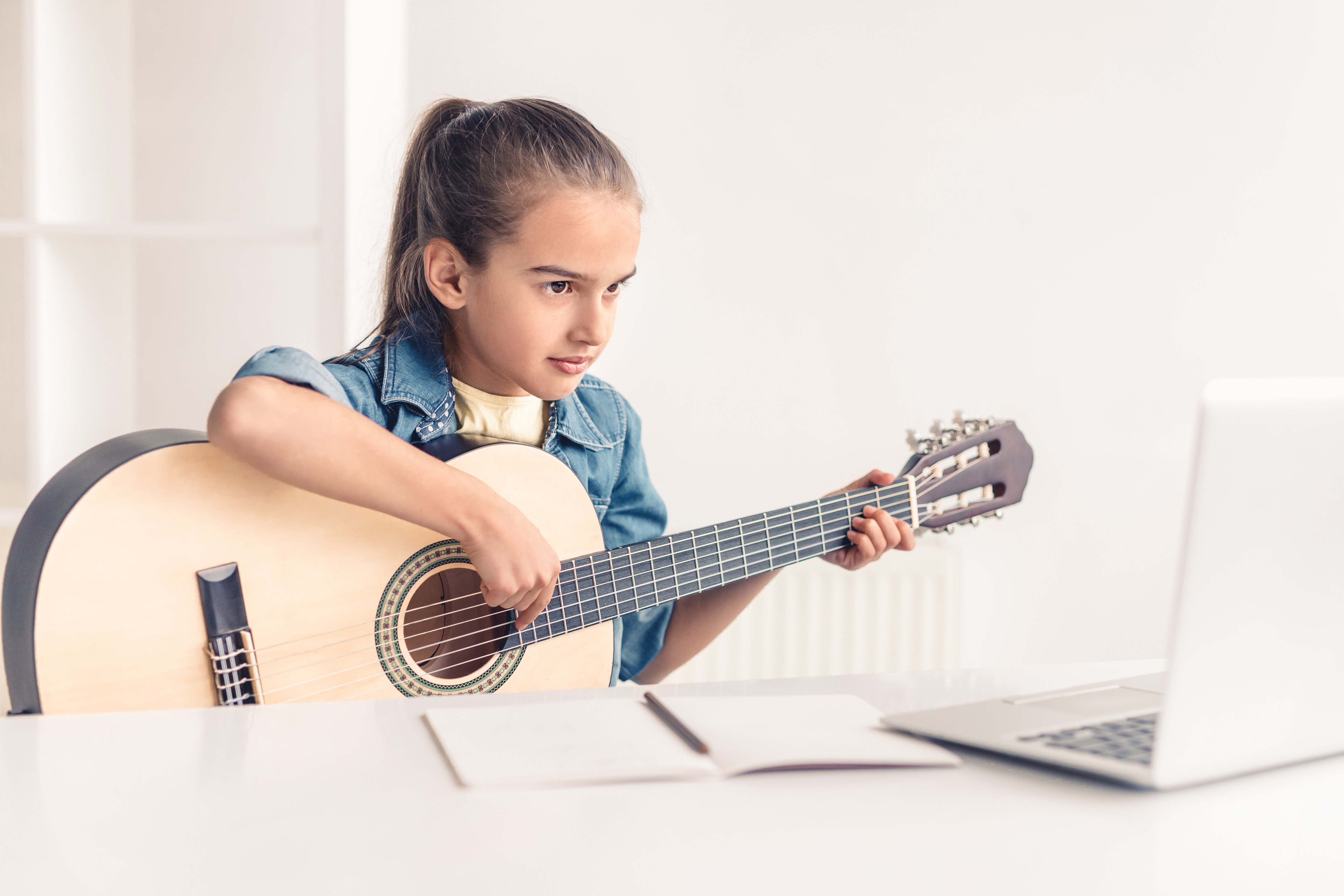 girl learning guitar at home 